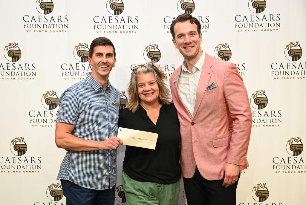 Caesar Grant Awards 06-24-26-75 - Extol Media Three adults pose for a photo at a Caesar's Foundation event; one holds an envelope.